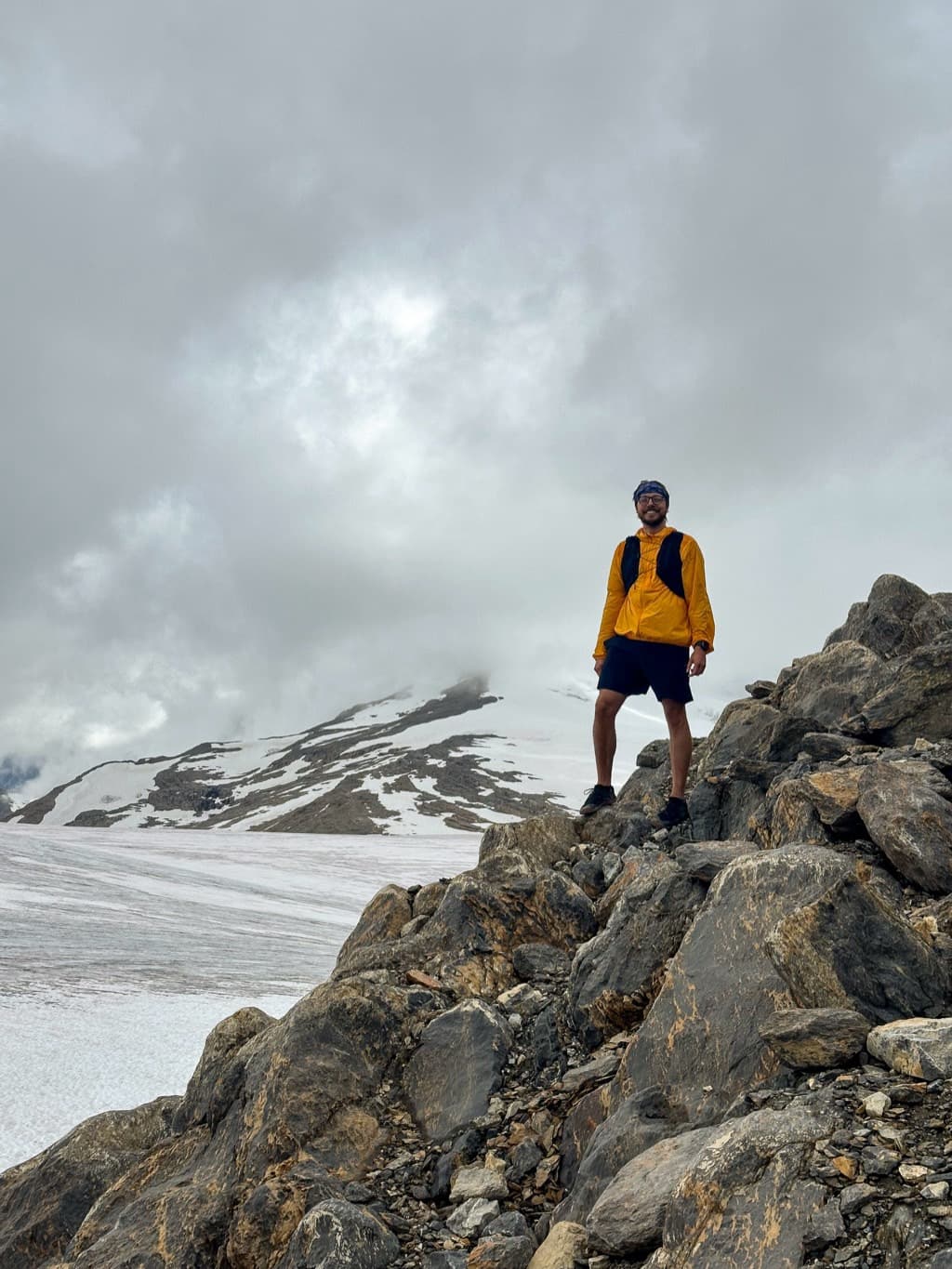 Croix standing on a rocky ridge above a glacier in the mountains